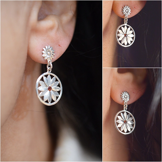 Handmade sterling silver floral earrings with natural garnet stone, worn on ear