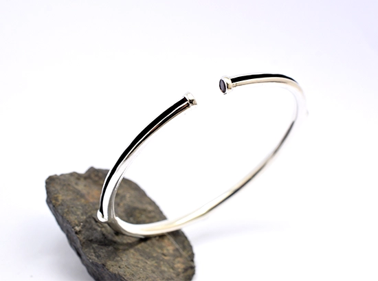 Ασημένιο ανοιχτό βραχιόλι 925 με πέτρα γρανάτη, μέγεθος medium, εσωτερική διάμετρος 6 εκ., σε σκούρα πέτρα — λευκό φόντο