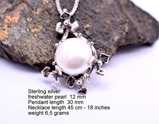 Handmade 925 sterling silver floral pendant necklace with 12mm freshwater pearl on dark stone background