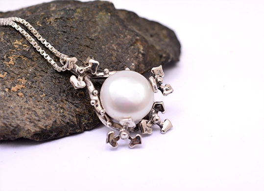 pearl sterling silver pendant Side view of floral pearl pendant showing depth of silver petals and pearl setting